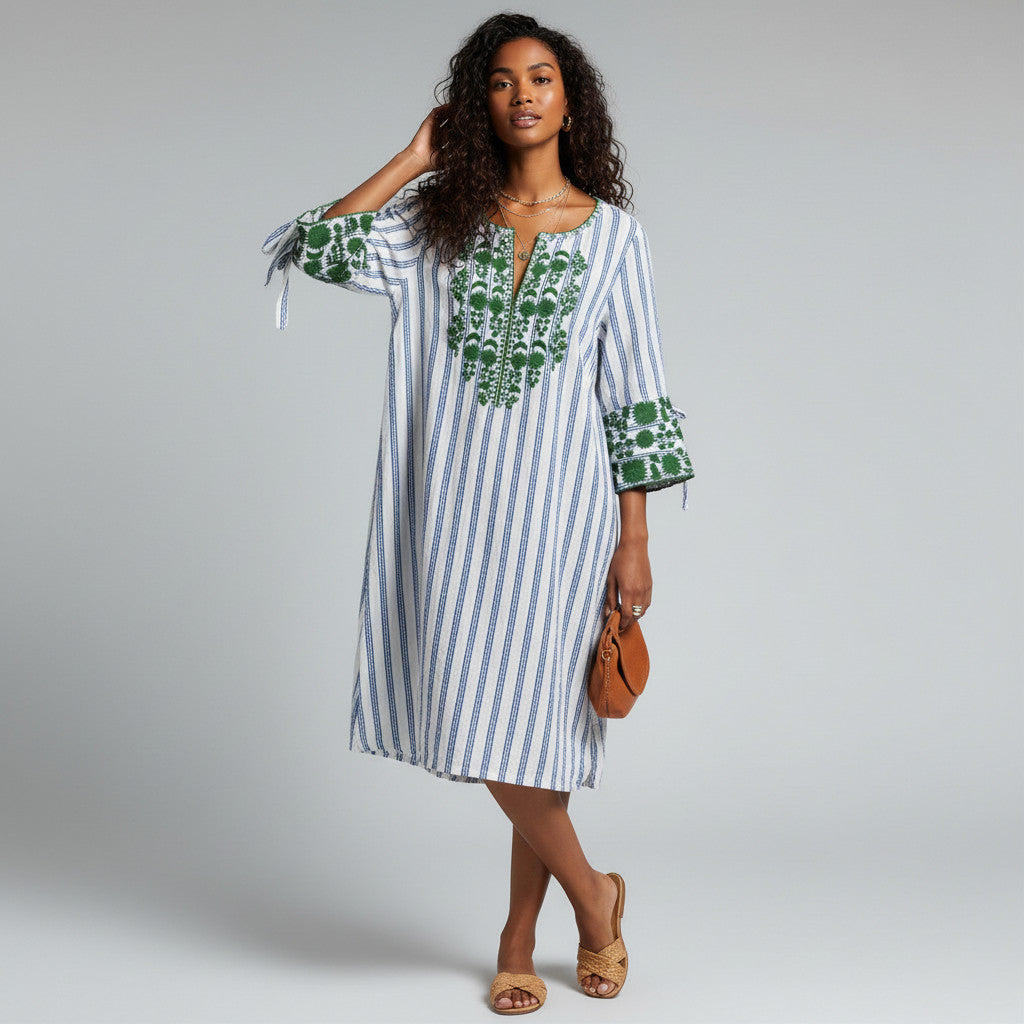 Model wearing a Lynn's Closet Boutique Rungolee white and blue striped shift dress with green floral embroidery