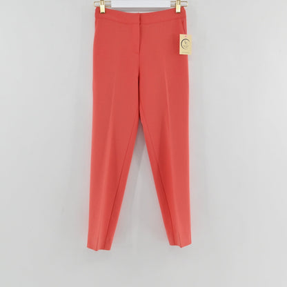 Lynn's Closet Boutique St. John coral slim-leg trousers with a clean waistband and pressed creases hanging on a hanger.