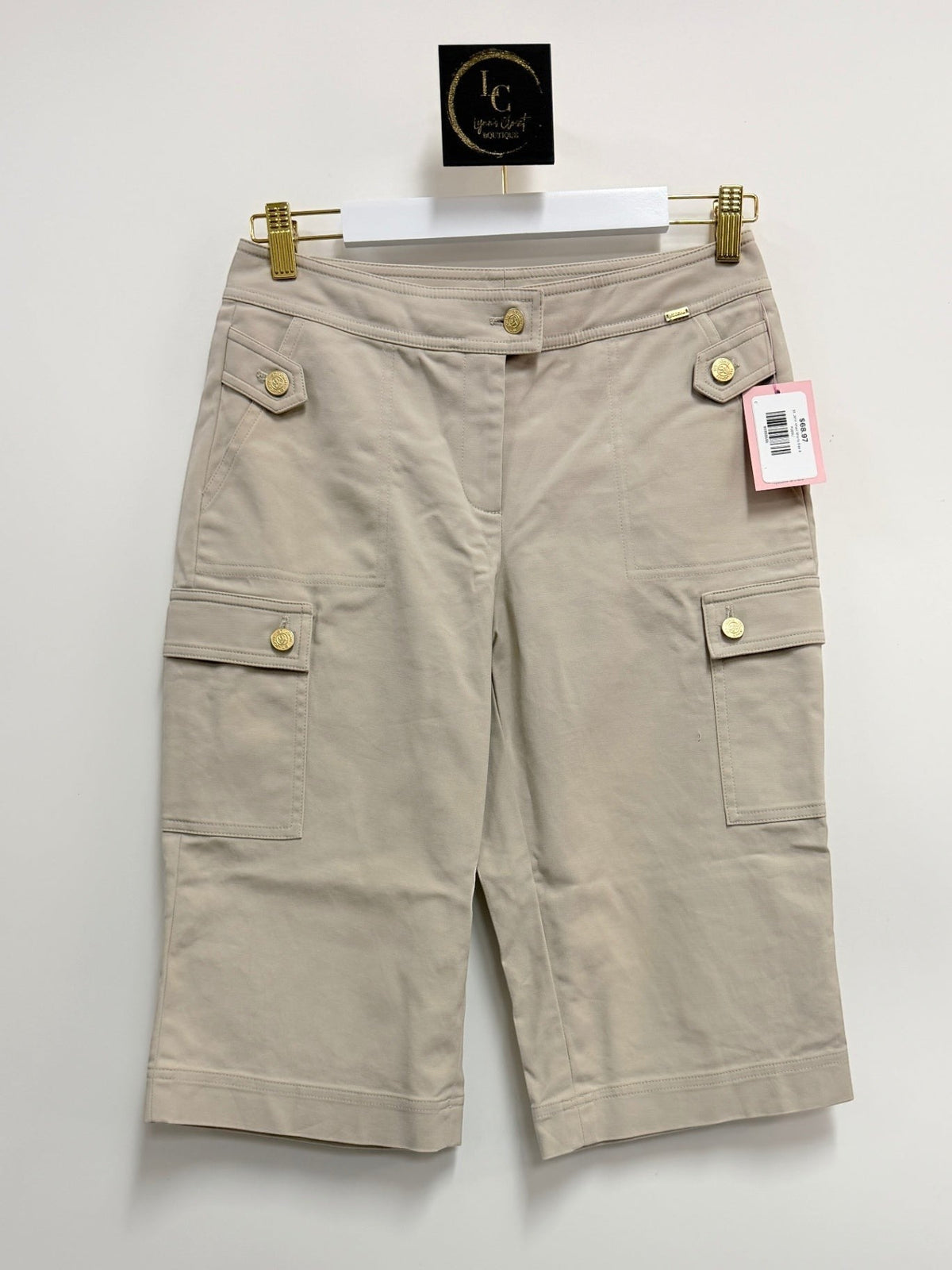 Lynn's Closet Boutique St. John khaki cotton blend cargo shorts with gold-tone button details hanging on a white hanger