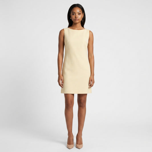 Model wearing a Steven Stolman butter yellow sleeveless shift dress with a boat neckline from Lynn's Closet Boutique.