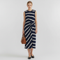 Model wearing a Lynn's Closet Boutique Tanya Taylor navy and cream striped midi dress with a twist front detail.