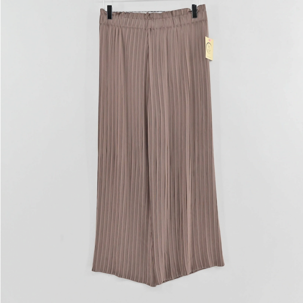 Lynn's Closet Boutique tan pleated wide-leg trousers with an elasticized waistband hanging on a hanger.