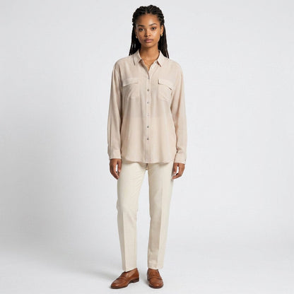 Model wearing Lynn's Closet Boutique tan silk-blend button-down shirt with chest pockets and cream trousers