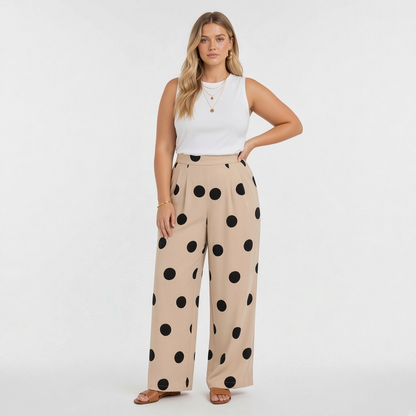 Model wearing Lynn's Closet Boutique beige wide-leg pants with black polka dots and a white sleeveless top