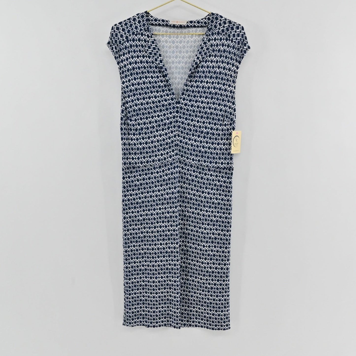 Lynn's Closet Boutique Tory Burch navy and white diamond print V-neck dress with cap sleeves hanging on a hanger.