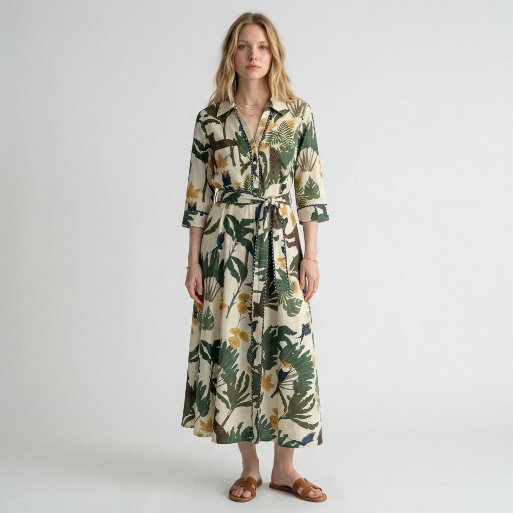 Model wearing a Lynn's Closet Boutique Just Darviny midi shirt dress with a tropical leaf print and tie waist
