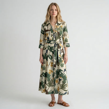 Model wearing a Lynn's Closet Boutique Just Darviny midi shirt dress with a tropical leaf print and tie waist