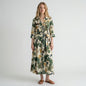 Model wearing a Lynn's Closet Boutique Just Darviny midi shirt dress with a tropical leaf print and tie waist