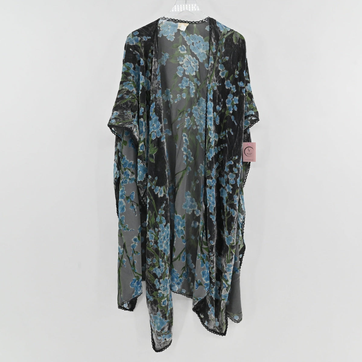 Lynn's Closet Boutique velvet burnout floral shawl in black and blue with scalloped lace trim hanging on a hanger.