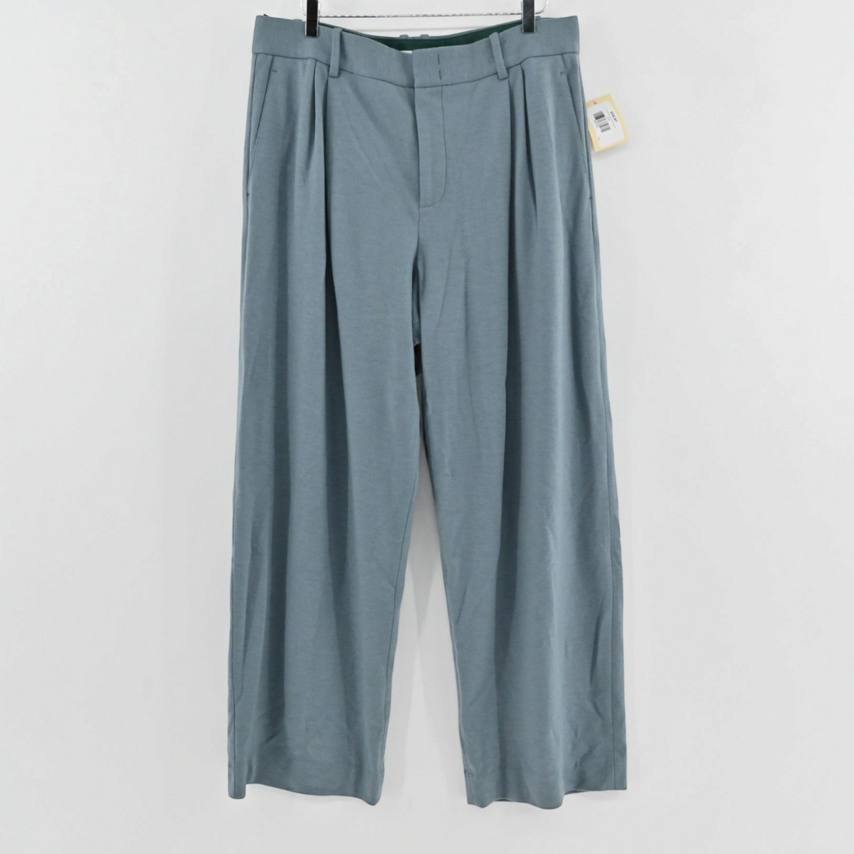 Lynn's Closet Boutique Vince blue-grey wide-leg trousers with front pleats and belt loops hanging against a white wall.