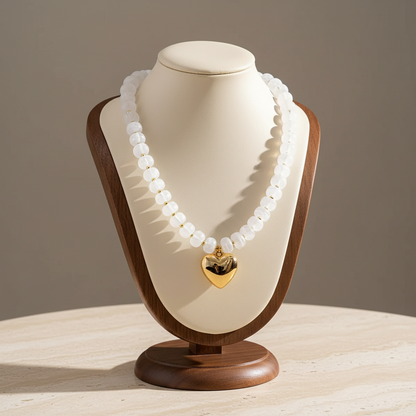 Lynn's Closet Boutique chunky white acrylic bead necklace with a polished gold-tone heart pendant on a display bust.