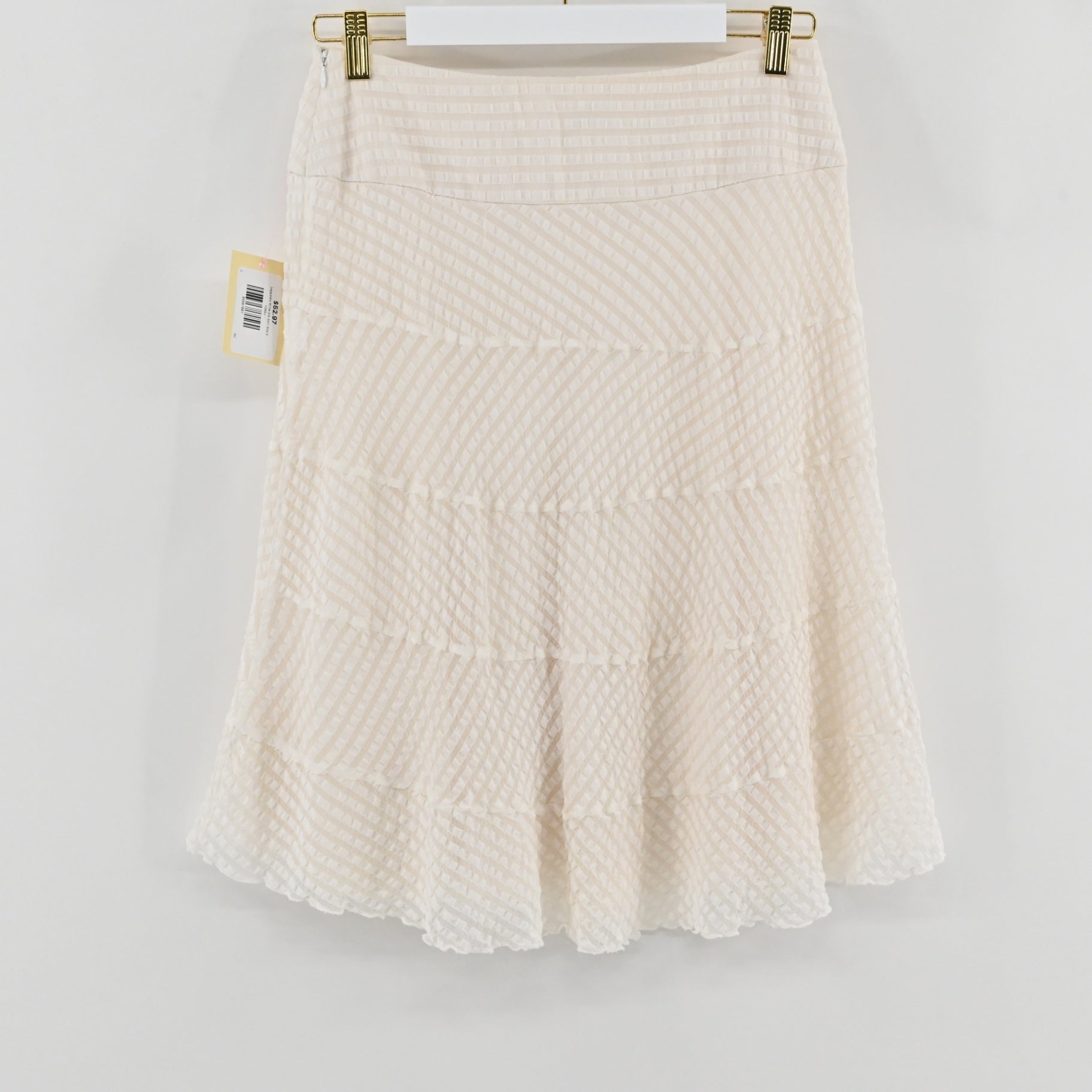 Lynn's Closet Boutique Leggiadro white silk skirt with textured tiered detailing hanging on a white hanger