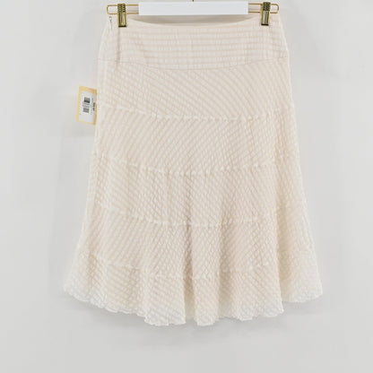 Lynn's Closet Boutique Leggiadro white silk skirt with textured tiered detailing hanging on a white hanger