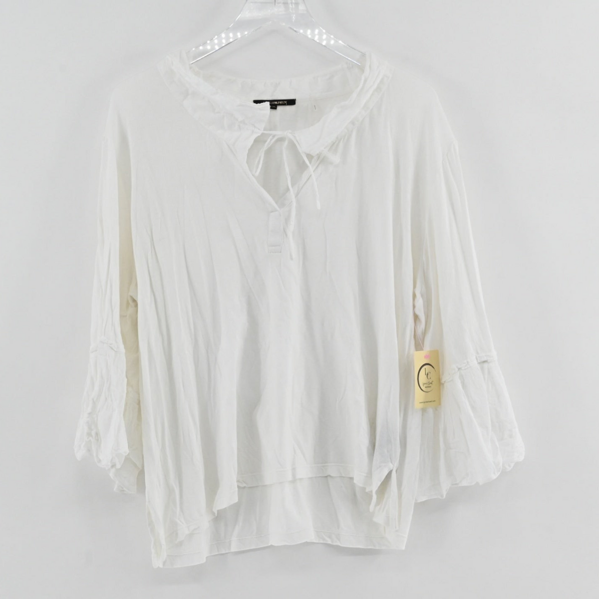 Lynn's Closet Boutique white Kobi Halperin tie-neck blouse with three-quarter sleeves and a high-low hemline.