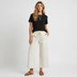 Model wearing Lynn's Closet Boutique white wide leg pants with a black t-shirt and brown sandals